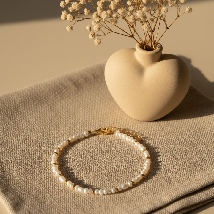 Miljøbillede af "Jeg Elsker Dig" armbåndet i et minimalistisk boheme-univers med varme jordtoner, creme og sandfarver. Alt står knivskarpt med fokus på sølvets tekstur.