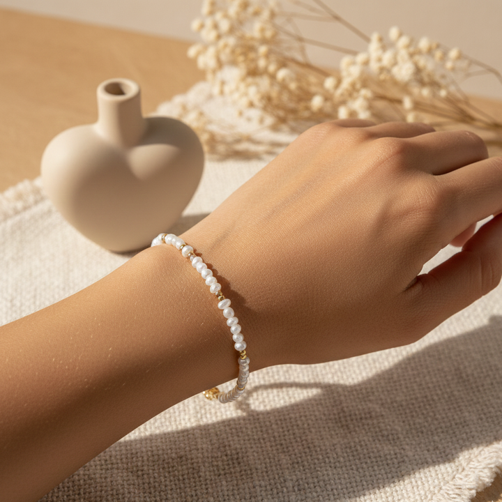 Nærbillede af det håndlavede "Jeg Elsker Dig" armbånd båret på et kvindehåndled med naturlig hudtone. Boheme-inspireret stil med fokus på 925 sterling forgyldte detaljerne